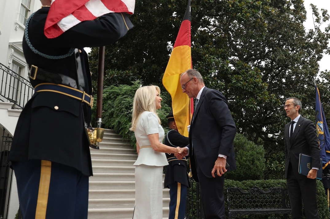 German Chancellor Friedrich Merz (R) is greeted by U.S. Chief of Protocol Monica Crowley as he arrives at the White House