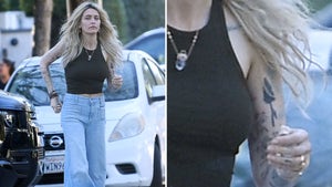 Paris Jackson Walking Down The Sidewalk Wearing Blue Jeans And A Black Tank Top