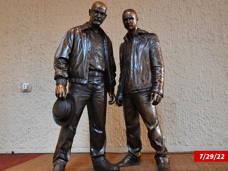 Bryan Cranston Aaron Paul pose with bronze statues