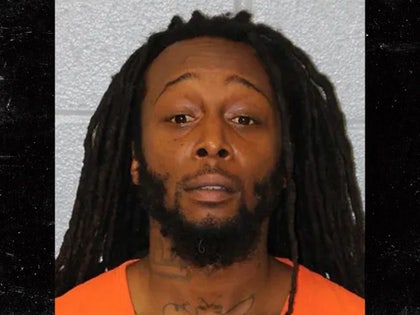 Decarlos Dejuan Brown is seen while posing for a mugshot. He's wearing an orange shirt.