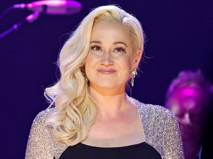 Kellie Pickler's seen at what appears to be a concert. She's wearing a dress with a black middle portion and rhinestone-covered sleeves, as well as a pair of earrings.