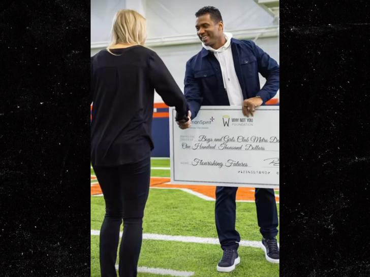 Russell Wilson handing over a check