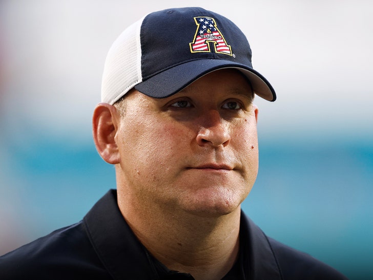 Shawn Clark is seen wearing a black polo and a multicolored hat with a large A on its front portion.