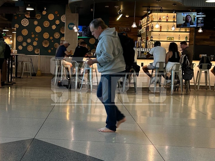 Bill Belichick barefoot in the airport 2
