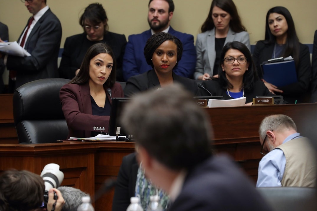 Rep. Alexandria Ocasio-Cortez (D-NY) listens as Michael Cohen, former attorney and fixer for President Donald Trump, testifies before the House Oversight Committee on Capitol Hill.