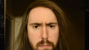 Twitch streamer Asmongold is seen frowning in a selfie. His long brunette hair's falling onto his shoulders.
