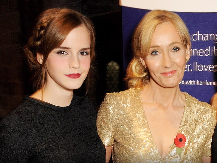 Emma Watson is seen while standing next to J.K. Rowling. Emma's wearing a black top, while J.K.'s wearing a gold dress and a flower-shaped pin.